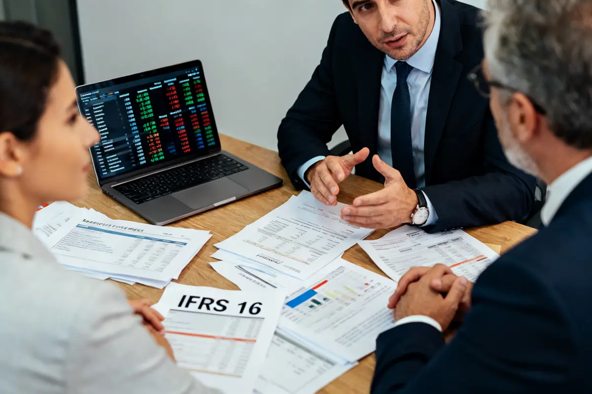 Réunion d'affaires sur IFRS 16 avec documents financiers et écran d'ordinateur portable