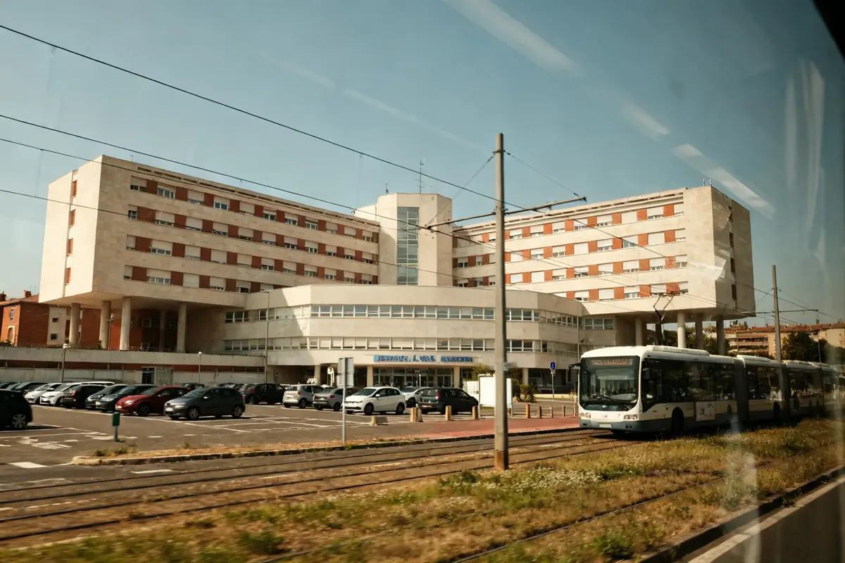 Tramway devant l'entrée principale de l'hôpital Larrey avec parking et bâtiments modernes